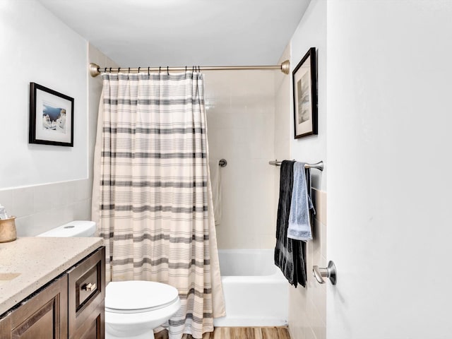 full bathroom featuring vanity, shower / tub combo with curtain, toilet, and tile walls