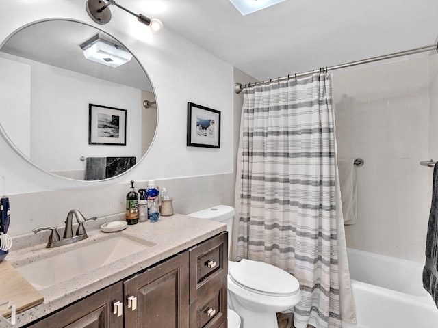 full bathroom featuring toilet, shower / bathtub combination with curtain, and vanity