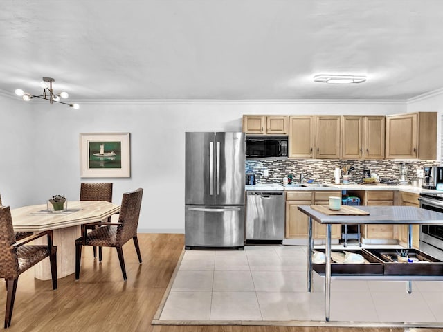 kitchen with light tile floors, a notable chandelier, tasteful backsplash, appliances with stainless steel finishes, and sink