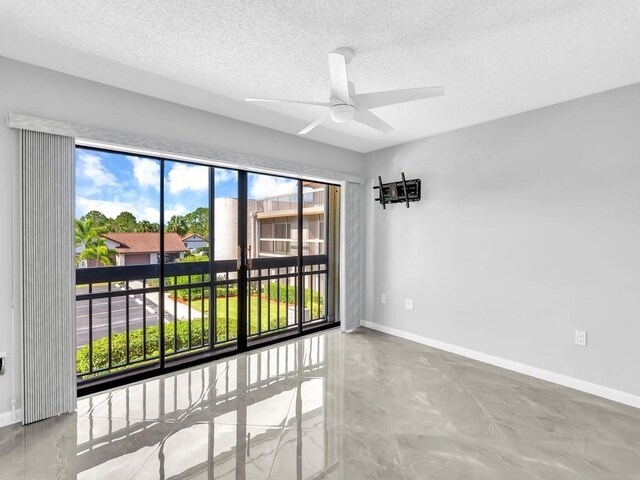 empty room with a textured ceiling, ceiling fan, and concrete flooring