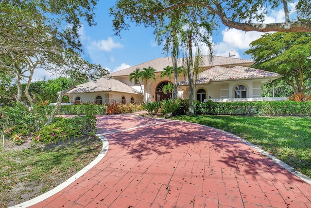 mediterranean / spanish-style home with a front lawn