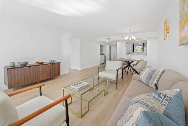 living room with a notable chandelier and light wood-type flooring