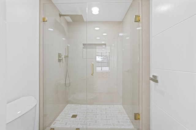 bathroom featuring walk in shower and toilet