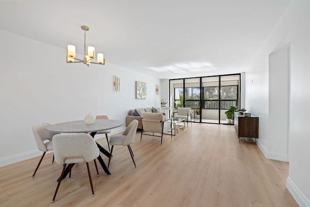 dining room featuring an inviting chandelier, light hardwood / wood-style floors, and a wall of windows