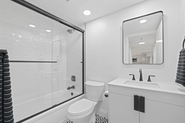 full bathroom featuring tile floors, toilet, vanity, and bath / shower combo with glass door