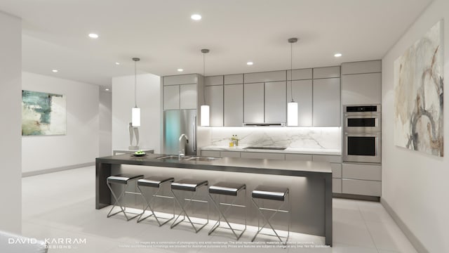 kitchen featuring a kitchen bar, decorative light fixtures, tasteful backsplash, and an island with sink