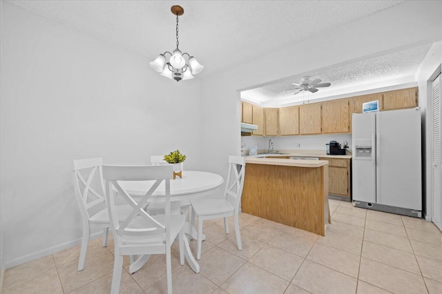 kitchen featuring decorative light fixtures, ceiling fan with notable chandelier, white fridge with ice dispenser, light tile floors, and a textured ceiling