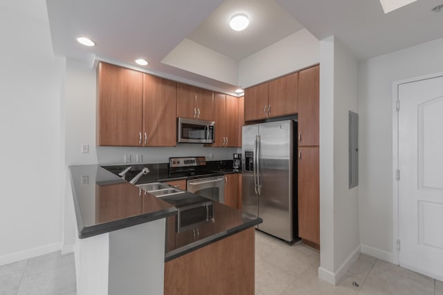 kitchen featuring kitchen peninsula, sink, light tile patterned floors, and stainless steel appliances