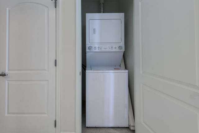 washroom with light tile patterned floors and stacked washer / dryer