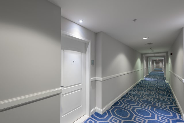 hallway featuring dark colored carpet