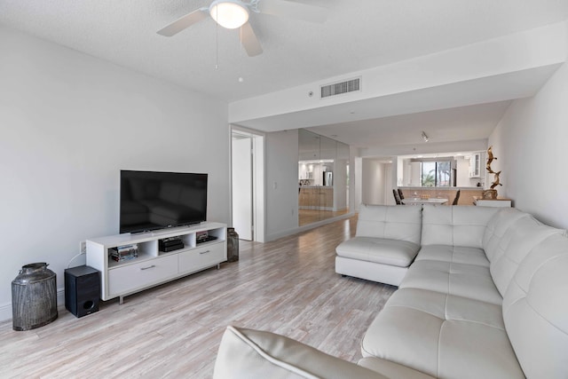 living room with light hardwood / wood-style floors and ceiling fan