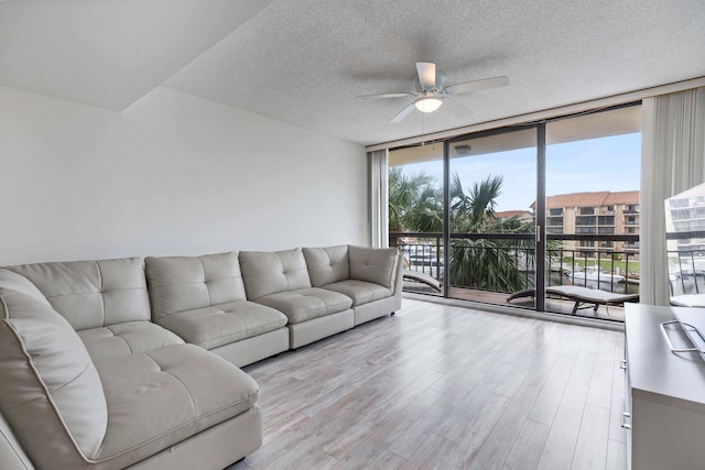 living room featuring floor to ceiling windows, light wood-type flooring, and plenty of natural light