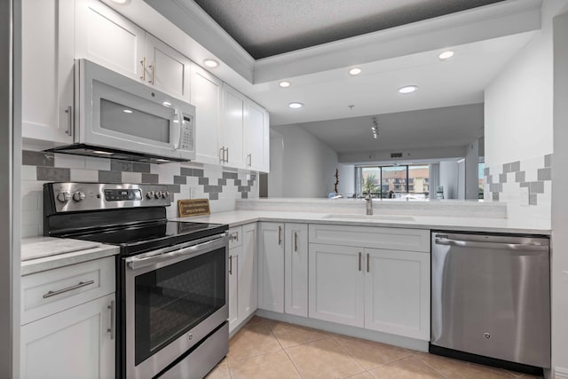 kitchen featuring appliances with stainless steel finishes, backsplash, white cabinetry, and sink