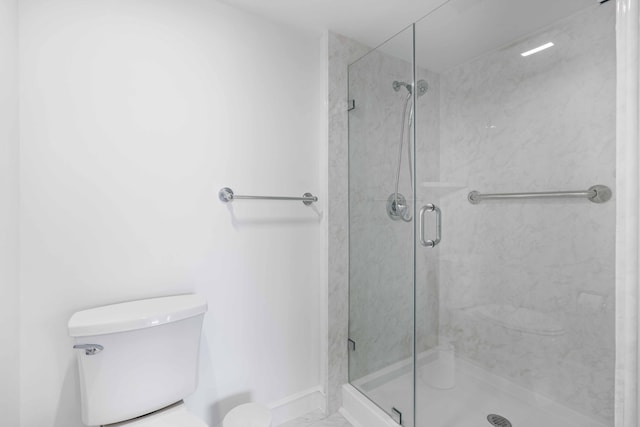 bathroom with a shower with door and toilet