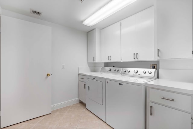 laundry room featuring light tile flooring, cabinets, electric dryer hookup, and separate washer and dryer