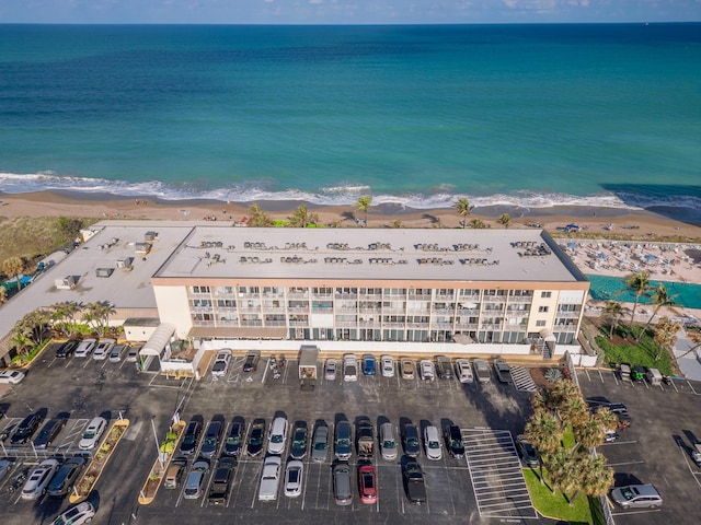 drone / aerial view with a water view and a beach view
