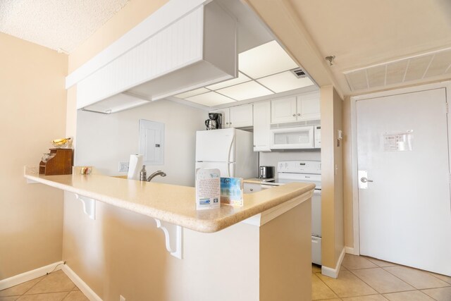 kitchen with white cabinets, white appliances, sink, and light tile flooring