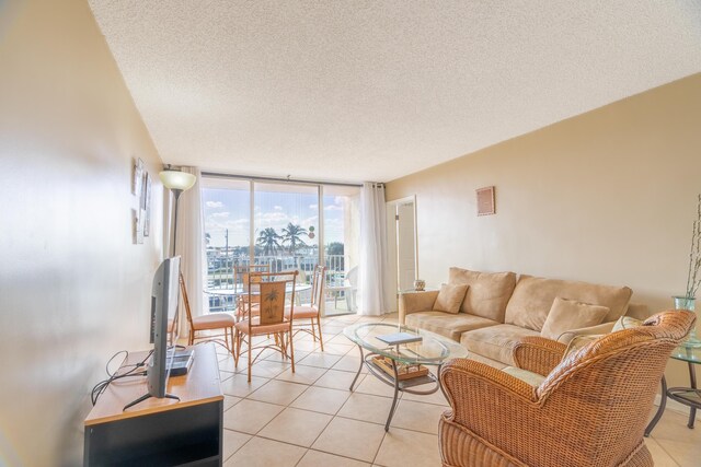 living room with light tile flooring, floor to ceiling windows, and a textured ceiling