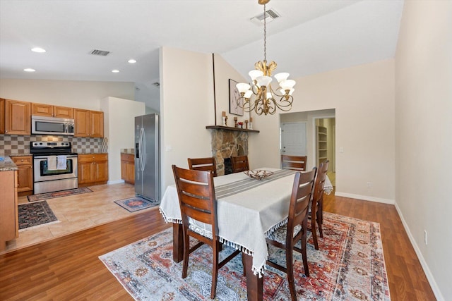 tiled dining area with a notable chandelier and vaulted ceiling