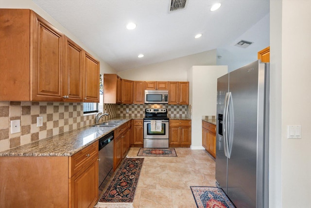 kitchen featuring appliances with stainless steel finishes, sink, light tile floors, light stone counters, and tasteful backsplash