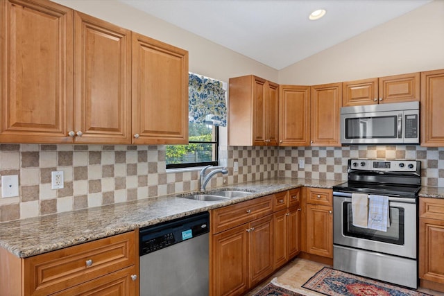 kitchen featuring sink, appliances with stainless steel finishes, light stone countertops, tasteful backsplash, and lofted ceiling