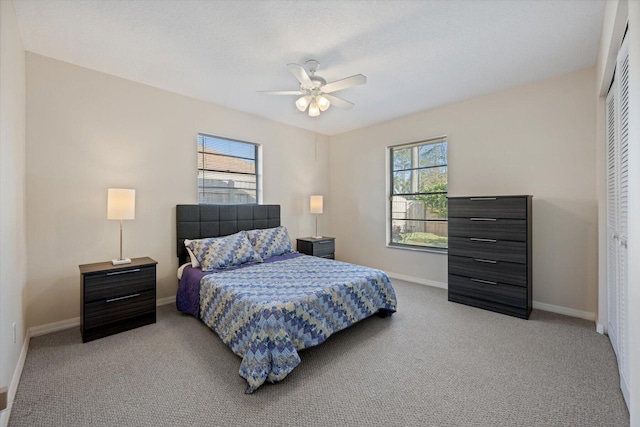 carpeted bedroom featuring ceiling fan, a closet, and multiple windows