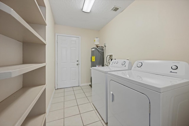 laundry area with light tile floors, a textured ceiling, separate washer and dryer, and hookup for a washing machine