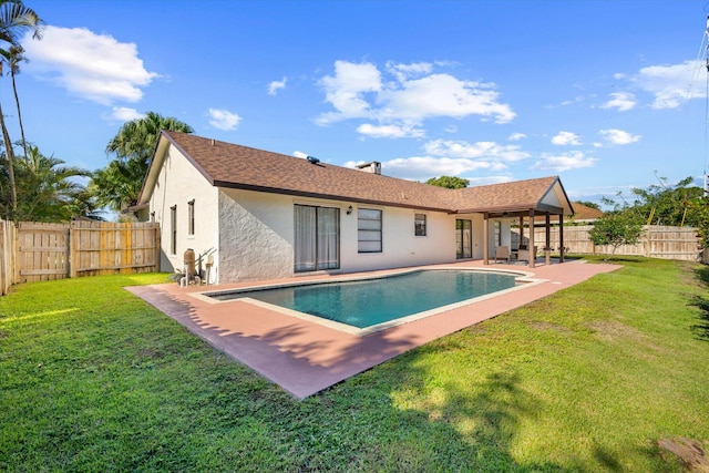 rear view of house featuring a lawn, a patio area, and a fenced in pool