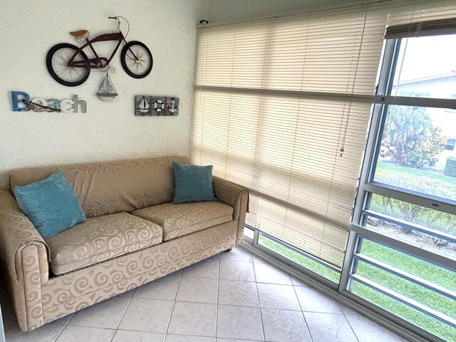 laundry area with washing machine and clothes dryer and light tile flooring