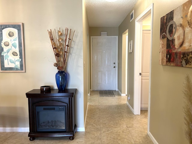 corridor featuring light tile floors and a textured ceiling