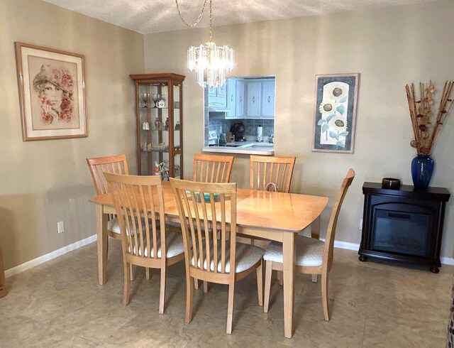 tiled dining area with a textured ceiling and a notable chandelier