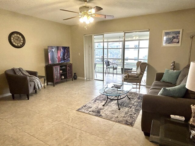 living room with light tile floors, a textured ceiling, and ceiling fan