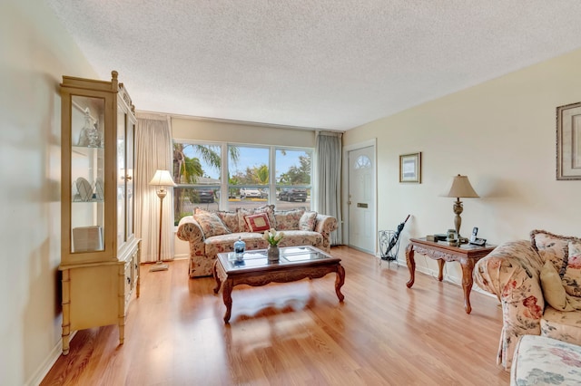 living room featuring a textured ceiling and light wood-type flooring