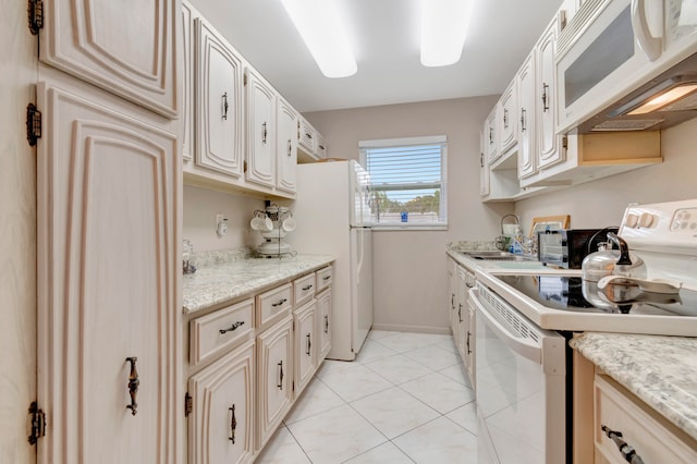 kitchen with white appliances, sink, light stone countertops, and light tile floors