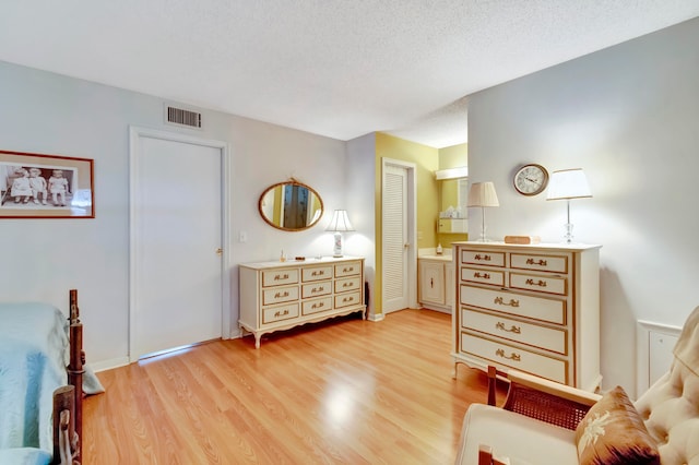 sitting room with a textured ceiling and light hardwood / wood-style flooring