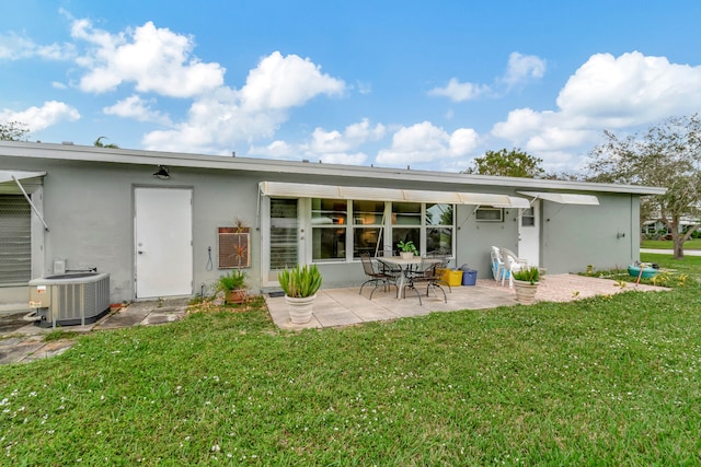 back of house with a yard, a patio area, central AC, and a wall mounted AC