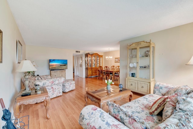 living room featuring an inviting chandelier and light hardwood / wood-style flooring