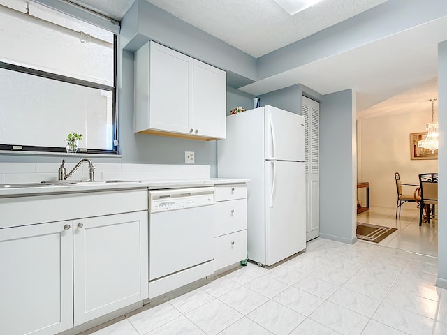 kitchen with an inviting chandelier, light tile flooring, white appliances, white cabinetry, and sink