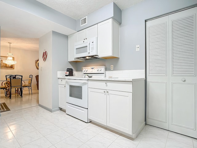 kitchen featuring white appliances, white cabinets, a textured ceiling, and light tile floors