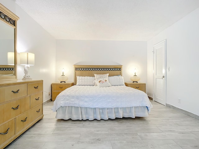 bedroom featuring a textured ceiling and light hardwood / wood-style floors