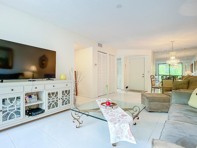 tiled living room featuring an inviting chandelier and a textured ceiling