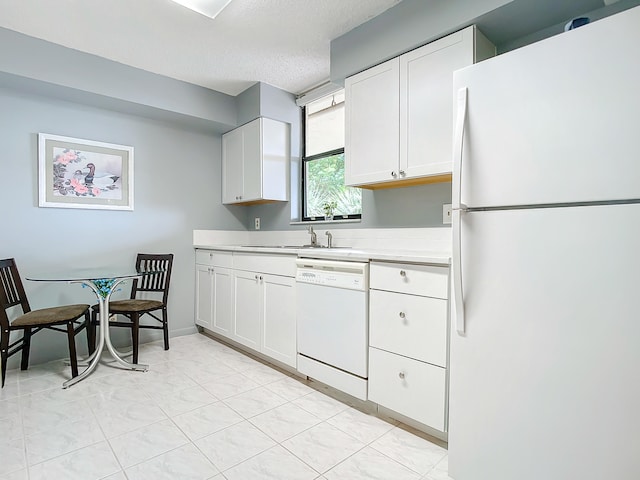 kitchen featuring white appliances, white cabinets, sink, and light tile floors