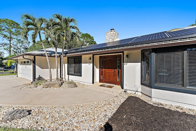 view of front of house with covered porch, solar panels, and a garage