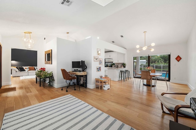 interior space featuring light hardwood / wood-style flooring, a chandelier, and vaulted ceiling