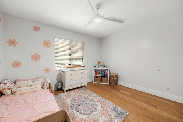 bedroom with hardwood / wood-style flooring, ceiling fan, and a textured ceiling