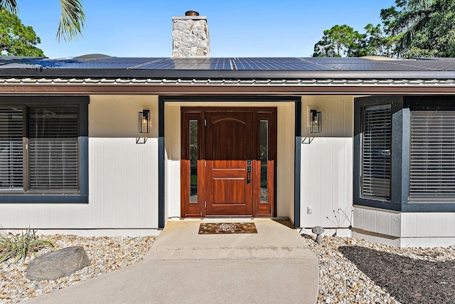 view of exterior entry featuring covered porch