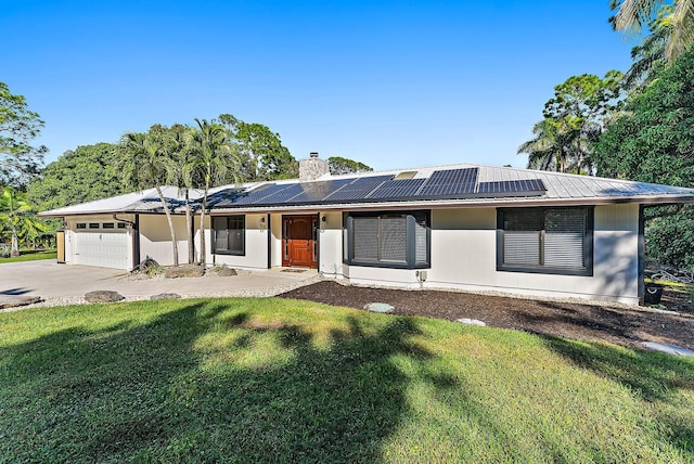 ranch-style house with a front yard, solar panels, and a garage