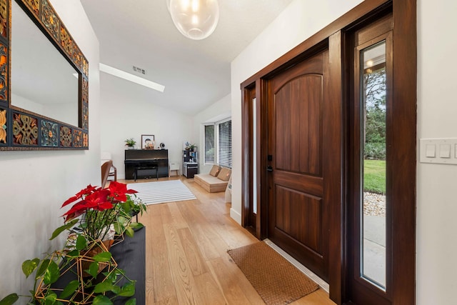 entrance foyer featuring light hardwood / wood-style floors and vaulted ceiling