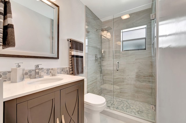 bathroom featuring an enclosed shower, toilet, and vanity