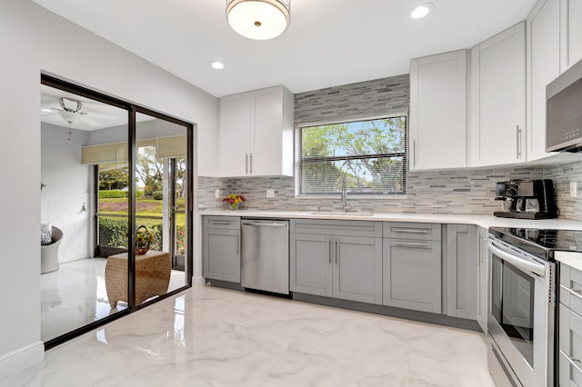 kitchen featuring ceiling fan, gray cabinets, light tile floors, sink, and appliances with stainless steel finishes